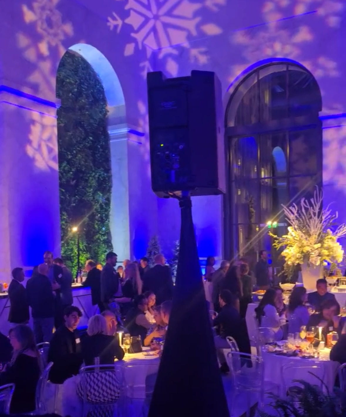 Custom color-matched uplighting and vibrant stage production transforming a corporate party and brand activation space.